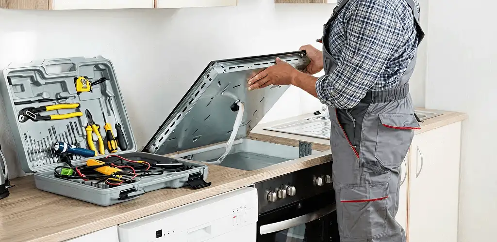 Handyman repairing a cooktop and checking wiring connections in Chicago, IL