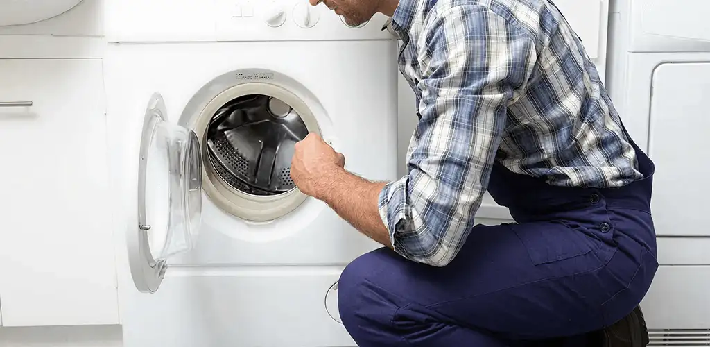 Handyman inspecting a dryer drum and internal parts for repair in Chicago, IL