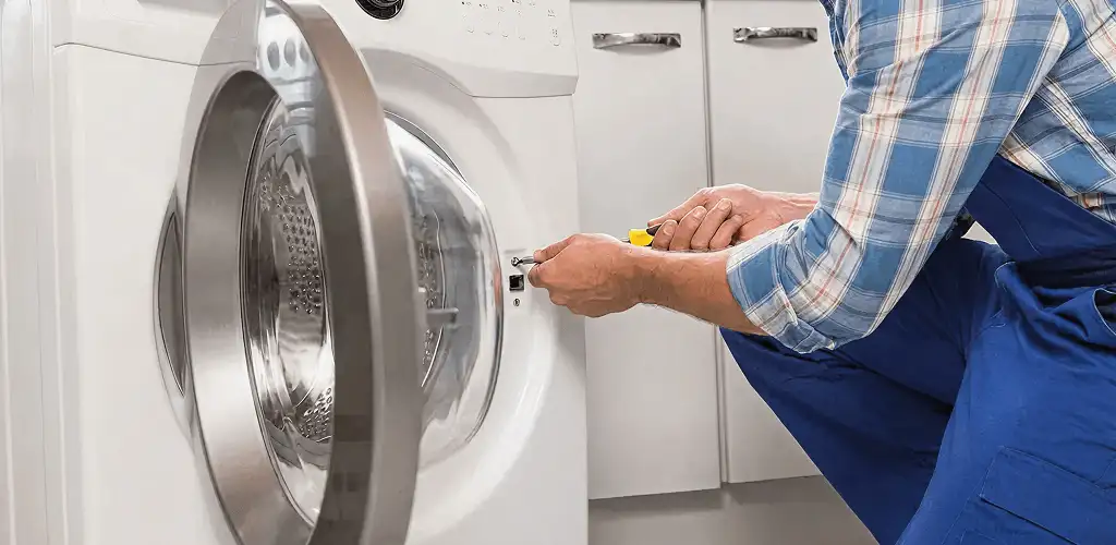 Handyman repairing a clothes dryer and checking electrical connections in Chicago, IL