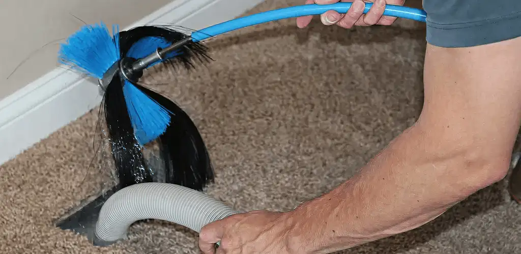 Dryer vent cleaning technician brushing lint from a vent line in Chicago, IL