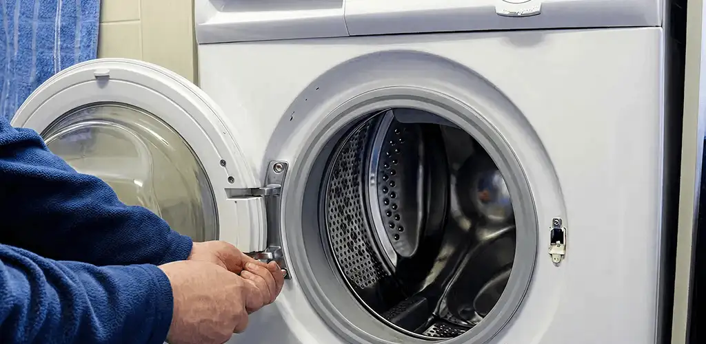 Washing machine repair handyman checking a front-load washer door and latch in Chicago, IL