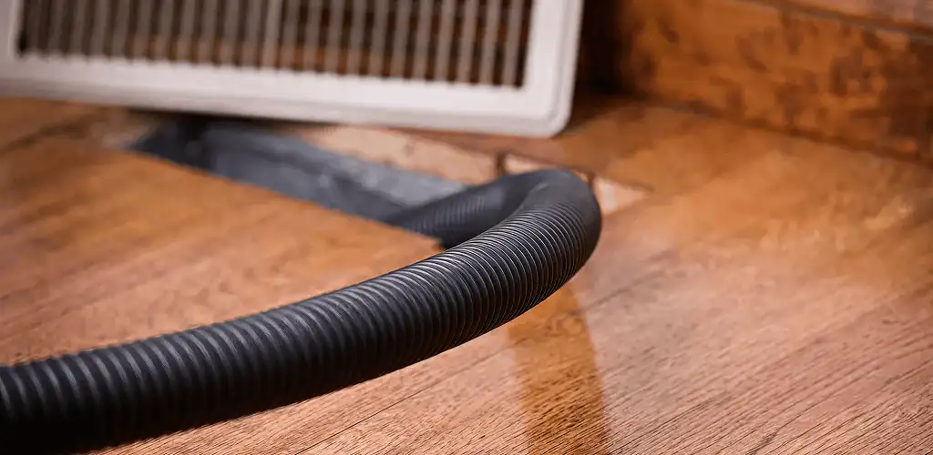 Air duct cleaning hose inserted into a floor vent for ductwork cleaning in Chicago, IL