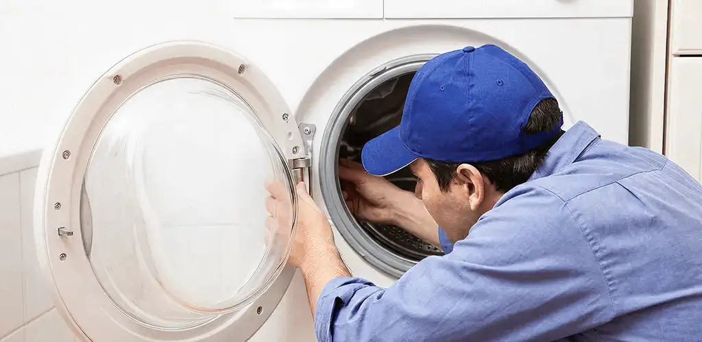 Washing machine repair handyman inspecting a front-load washer drum in Chicago, IL